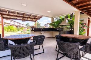an outdoor patio with two tables and chairs at condominio viva barra barra grande casa 136 in Marau