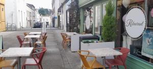a row of tables and chairs on a street at Au Bon oranger, Appartement en coeur de ville hyper centre in Cholet