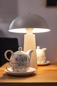 a tea pot on a table next to a lamp at Elbląg Stare Miasto Bulvar, Old Town, Snake in Elblag