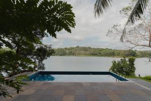 a swimming pool next to a body of water at Lakedale Resorts in Thekkumkara