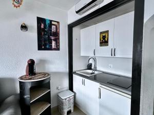 a small kitchen with a sink and white cabinets at Estupendo Dúplex en Sierra Nevada in Monachil +20 photos