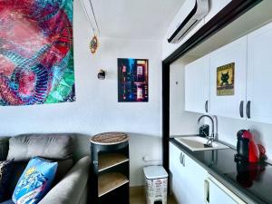a kitchen with a couch and a sink in a room at Estupendo Dúplex en Sierra Nevada in Monachil