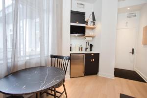 a kitchen and dining room with a table and a small table at Studio #8 - Self Check-In - Plateau - St-Denis in Montreal