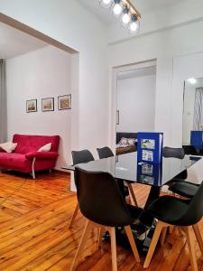 a dining room with a table and chairs and a red couch at Top Center Vasil Levski 2BDR ACC Apartment by SofiaLuxRentals in Sofia