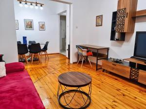 a living room with a tv and a table and chairs at Top Center Vasil Levski 2BDR ACC Apartment by SofiaLuxRentals in Sofia