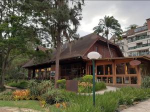 a building with a palm tree in front of a building at Apto Casinha de Boneca no Verde in Itaipava