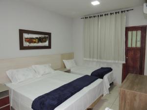 a hotel room with two beds and a window at Hotel Continental - Próximo ao Mercado Central, Mercado Novo e a Rodoviária in Belo Horizonte