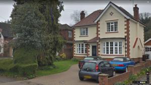 a house with two cars parked in front of it at Leafy Suburban Bed and Breakfast in Northwood