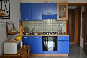 a kitchen with blue cabinets and a sink and a microwave at Casa Pura Vida in Quartu SantʼElena