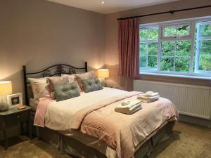a bedroom with a bed with two towels on it at Leafy Suburban Bed and Breakfast in Northwood +13 photos