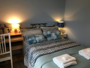 a bedroom with a bed with two towels on it at Leafy Suburban Bed and Breakfast in Northwood