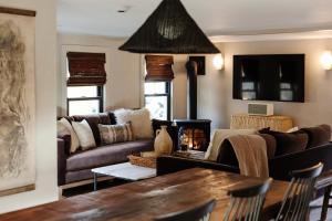 ein Wohnzimmer mit Sofas, einem Tisch und einem Kamin in der Unterkunft The Bend in Phoenicia