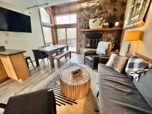 a living room with a couch and a table at Cozy Townhome at Lutsen Mtn - Ski-in, Ski-out, Pool, Hot Tub, Fitness Center, resort amenities galore! in Lutsen