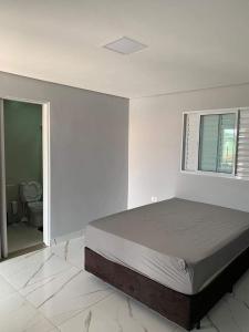 a bedroom with a large bed and a window at Nosso Recanto Alicia e Miguel in Ibiúna +51 photos