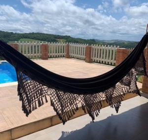 a hammock on a balcony overlooking a pool at Nosso Recanto Alicia e Miguel in Ibiúna