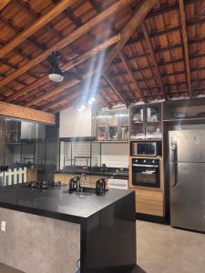 a kitchen with a black counter top and a refrigerator at Nosso Recanto Alicia e Miguel in Ibiúna