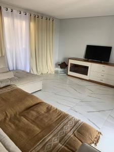 a bedroom with a bed and a tv on a dresser at Nosso Recanto Alicia e Miguel in Ibiúna