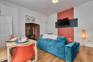 SeahamにあるRelaxing 3-Bedroom Home Near the Beachの青いソファとテーブルのあるリビングルーム