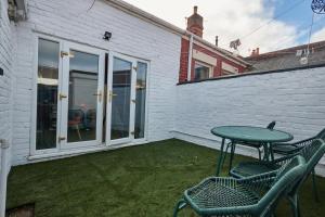 SeahamにあるRelaxing 3-Bedroom Home Near the Beachの芝生の上にテーブルと椅子付きのパティオ