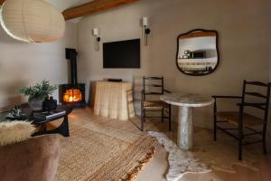 ein Wohnzimmer mit einem Tisch und einem Kamin in der Unterkunft The Bend in Phoenicia