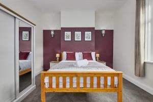 SeahamにあるRelaxing 3-Bedroom Home Near the Beachのベッドルーム(木製ベッド1台、鏡付)