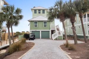 a large green house with palm trees in front of it at NEW- Gulf Front home 4 bed 4 bath in Indian Pass