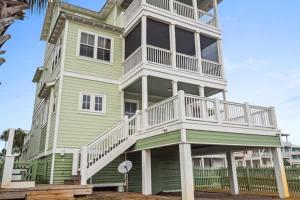a large green house with a balcony on it at NEW- Gulf Front home 4 bed 4 bath in Indian Pass