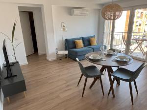 a living room with a table and a blue couch at Rincón del Mar in Cala del Moral