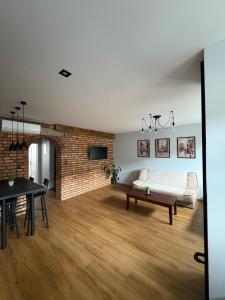 a living room with a white couch and a brick wall at Kościuszki in Sanok +19 photos