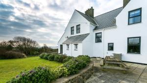 a white house with a garden in front of it at Moranedd in Llanfaethlu