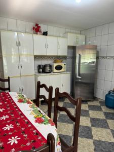 a kitchen with a table and chairs and a refrigerator at Chácara Leão Dourado in Pôrto Feliz