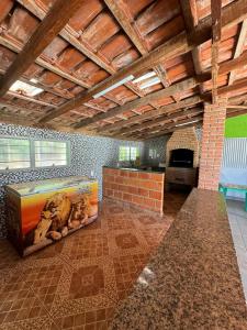 a kitchen with a pizza box and a brick wall at Chácara Leão Dourado in Pôrto Feliz