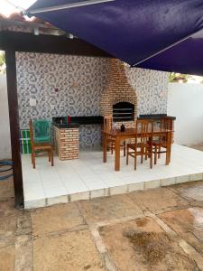 a patio with a table and chairs and a fireplace at Alugo Casa de Praia Luís Correia in Luis Correia