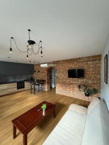 a living room with a couch and a brick wall at Kościuszki in Sanok +19 photos