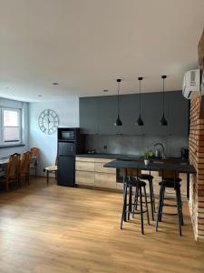 a kitchen with black cabinets and a table and chairs at Kościuszki in Sanok