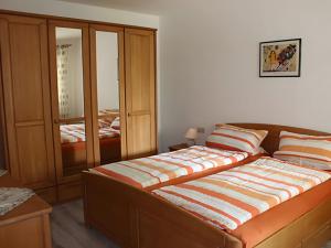 a bedroom with a bed and a cabinet at Ferienwohnungen Im Försterhaus in Lonsee