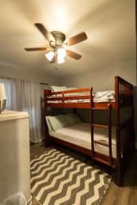 Un dormitorio con dos literas y un ventilador de techo. en Cozy country home in town, en Hastings