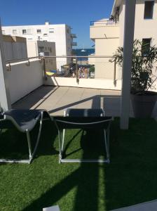a pair of chairs sitting on top of a balcony at Les plages du Grand Vallen - Résidence Château Leenhardt in Le Grau-du-Roi