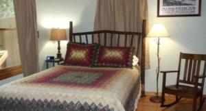 a bedroom with a bed and two lamps and a chair at Long Mountain Lodge Bed & Breakfast in Dahlonega
