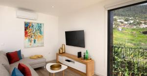 a living room with a couch and a tv at Marco 4 Seasons- Summer in Arco da Calheta