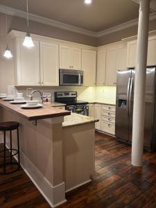 een keuken met witte kasten en een roestvrijstalen koelkast bij 305 Decatur st in New Orleans