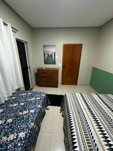 ein Schlafzimmer mit zwei Betten und einer Kommode in der Unterkunft CASA 04 próximo ao Centro in Palmas