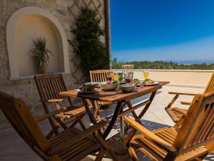 een houten tafel en stoelen op een terras bij Seistron Villa Part of Cretan Retreat in Patsídhes +23 foto's
