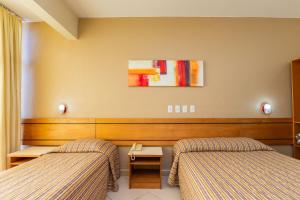 a hotel room with two beds in a room at Hotel Express Confort in São Leopoldo