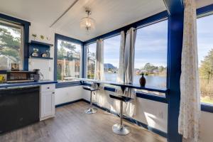 西塞德Fire Pit and River View Vintage Stay in Seaside!的有蓝色墙壁和大窗户的厨房