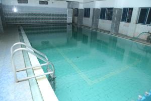 a large swimming pool with blue water at Ambika Residency & Mahal in Tiruttani