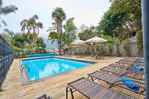 a swimming pool with chairs and a table at SESC POÇOS DE CALDAS in Poços de Caldas
