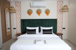 a bedroom with a large white bed with a green headboard at مساكن الدار للشقق الفندقية 13 in Abha