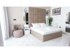 Un dormitorio con una cama grande y una silla. en Soco Apartment, en Lekki