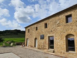 a stone building with windows on the side of it at Kaikna Podere Evolutivo in Montescudaio